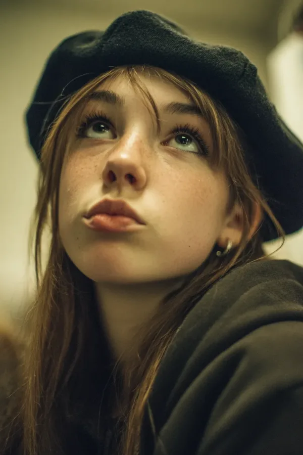 A 2013 tumblr teenage scene girl wearing a beret with layered hair, subtle lip gloss, wearing a vintage hoodie, mouth sl